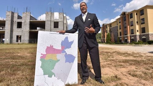 Jason Lary, the president for Stonecrest Yes, holds a map of the proposed city of Stonecrest as he talks about why he believes the area should incorporate in front of an unfinished hotel near Stonecrest Mall. Voters will decide whether to create the city of Stonecrest in a Nov. 8 referendum. HYOSUB SHIN / HSHIN@AJC.COM