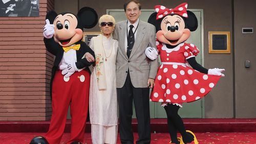 FILE - Mickey Mouse, from left, Elizabeth Gluck, Richard M. Sherman and Minnie Mouse pose for a photo at the ceremony honoring the Sherman Brothers with the rename of Disney Studios Soundstage A at the world premiere of Disney's "Christopher Robin" at the Walt Disney Studios, July 30, 2018, in Burbank, Calif. Sherman, one half of the prolific, award-winning pair of brothers who helped form millions of childhoods by penning classic Disney tunes, died Saturday, May 25, 2024. He was 95. (Photo by Willy Sanjuan/Invision/AP, File)