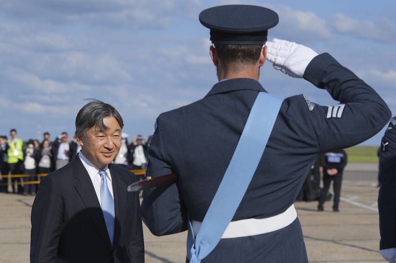 Emperor Naruhito is saluted by a member of the honour guard as he and Empress Masako arrive at Stansted Airport, England, Saturday, June 22, 2024, ahead of a state visit. The state visit begins Tuesday, when King Charles III and Queen Camilla will formally welcome the Emperor and Empress before taking a ceremonial carriage ride to Buckingham Palace. (AP Photo/Kin Cheung)