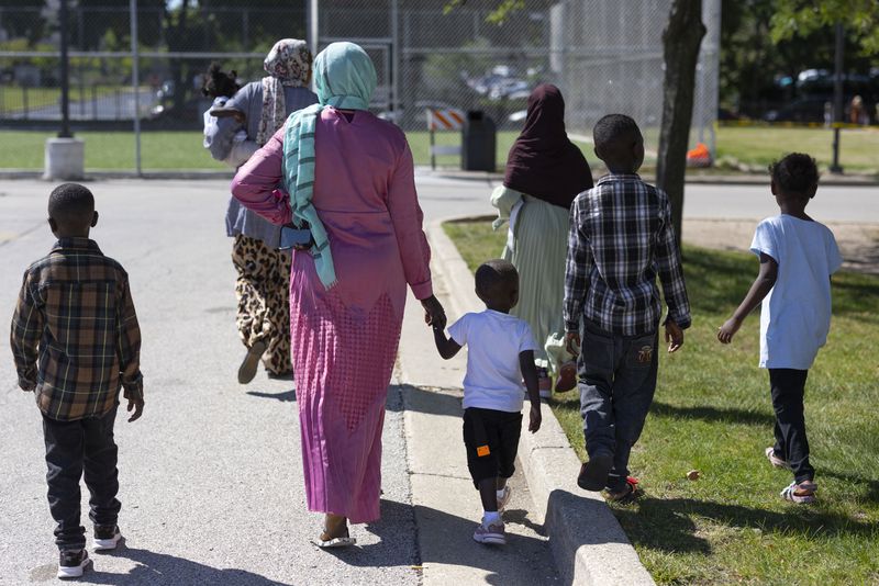 Children and adults attend a back to school health fair in Milwaukee, on Saturday Aug. 10, 2024. (AP Photo/Jeffrey Phelps)