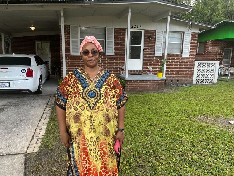 Georgia native and Jacksonville resident Crecie Washington stands in front of her home Sunday after three people were killed in her neighborhood on Saturday.