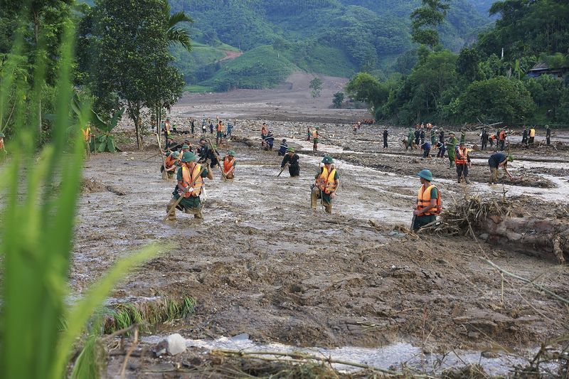 Rescue workers search for the missing after a flash flood buries a hamlet in mud and debris in the aftermath of Typhoon Yagi in Lao Cai province, Vietnam Thursday, Sept. 12, 2024. (Duong Van Giang/VNA via AP)