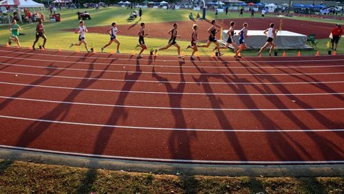 110506 - Jefferson, Ga. - The late afternoon sunlight casts long shadows of the lead pack during the Class AAAA 3,200 meter run final at the Boys High School Track event at Memorial Stadium Friday afternoon in Jefferson, Ga., May 6, 2011. Jason Getz jgetz@ajc.com