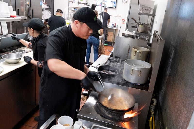 FILE - Family cousin Tito Thepkaysone cooks up some pad Thai at "Love & Thai" restaurant in Fresno, Calif., Wednesday, Dec. 20, 2023. The Thai restaurant, is back in operation after being wrongfully accused of abusing a dog to turn it into meat. It may be astonishing to some that a claim rooted in a racist stereotype took down a restaurant three years after "Stop Asian Hate" became a rallying cry. (AP Photo/Richard Vogel, File)