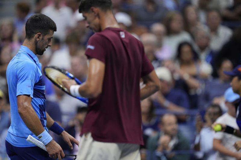 Novak Djokovic, of Serbia, walks past Alexei Popyrin, of Australia, during a third round match of the U.S. Open tennis championships, Friday, Aug. 30, 2024, in New York. (AP Photo/Julia Nikhinson)