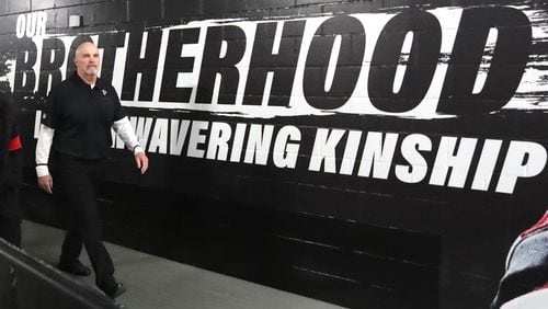 Falcons head coach Dan Quinn walks past the Brotherhood slogan in 2019.