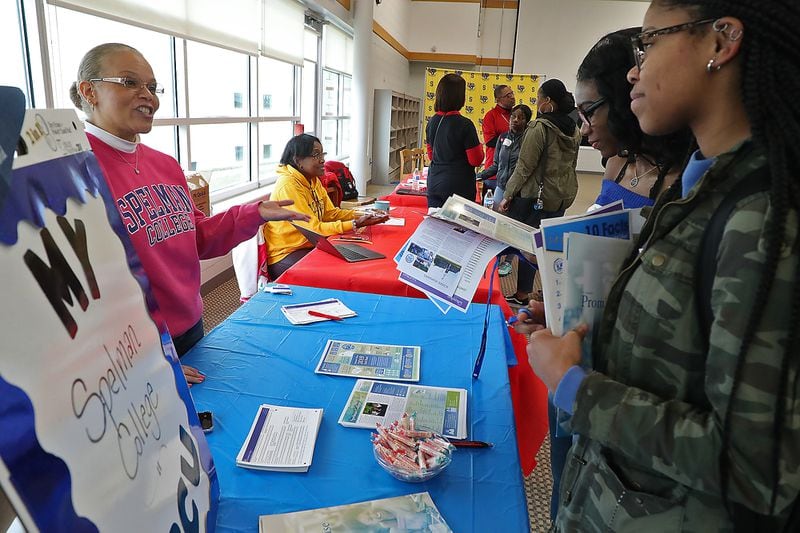 Springfield High School students Imani Fudge, left, and Nija Brown talk with Shannon Moore from Spelman College Friday during the HBCU Day at the school. 