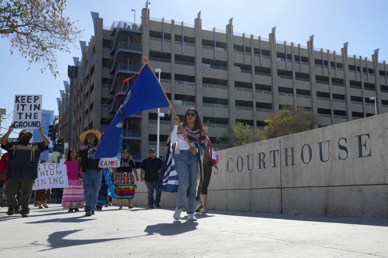 Loveena Watahomigie, right, lead members of the Hualapai Tribe as they march in front of U.S. District Court to try to persuade a federal judge to extend a temporary ban on exploratory drilling for a lithium project Tuesday, Sept. 17, 2024, in Phoenix. (AP Photo/Ross D. Franklin)