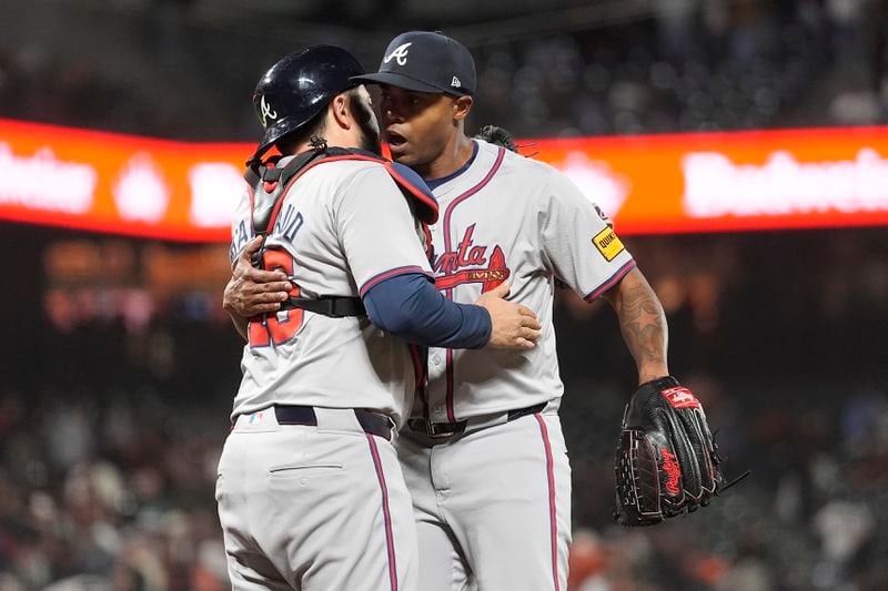 Atlanta Braves catcher Travis d'Arnaud, left, celebrates with pitcher Raisel Iglesias after the Braves defeated the San Francisco Giants in 10 innings of a baseball game in San Francisco, Monday, Aug. 12, 2024. (AP Photo/Jeff Chiu)