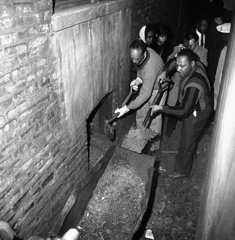 Martin Luther King and others attack slum conditions at an apartment building in Chicago, Illinois on Feb. 23, 1966, using shovels to clean up trash and ashes from the basement. (AP Photo/Edward Kitch)