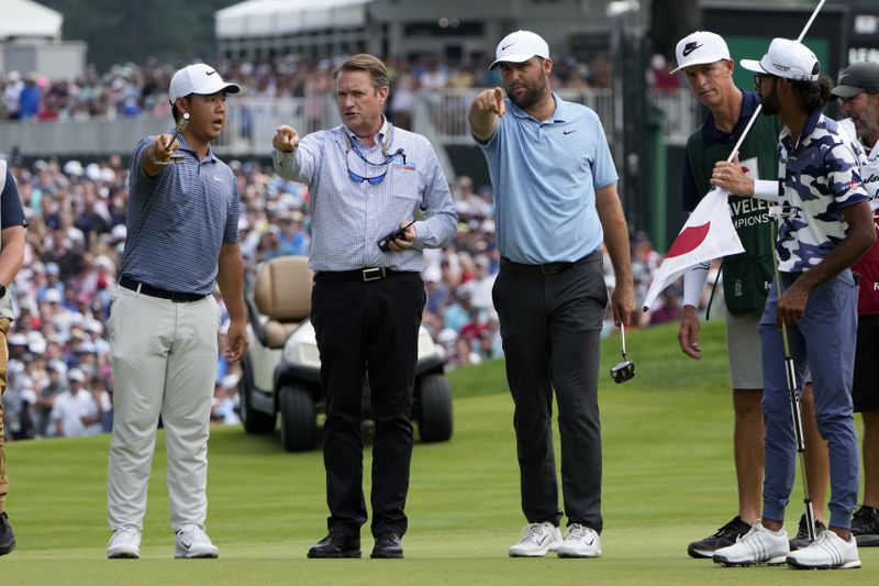 Golfers Tom Kim, left, of South Korea, Scottie Scheffler, center, and Akshay Bhatia, right, talk to an official after protesters ran onto the 18th green during the final round of the Travelers Championship golf tournament at TPC River Highlands, Sunday, June 23, 2024, in Cromwell, Conn. (AP Photo/Seth Wenig)