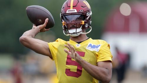 Washington Commanders quarterback Jayden Daniels throws a pass during an NFL football practice at the team's training facility in Ashburn, Va., Wednesday, July 24, 2023. (AP Photo/Luis M. Alvarez)