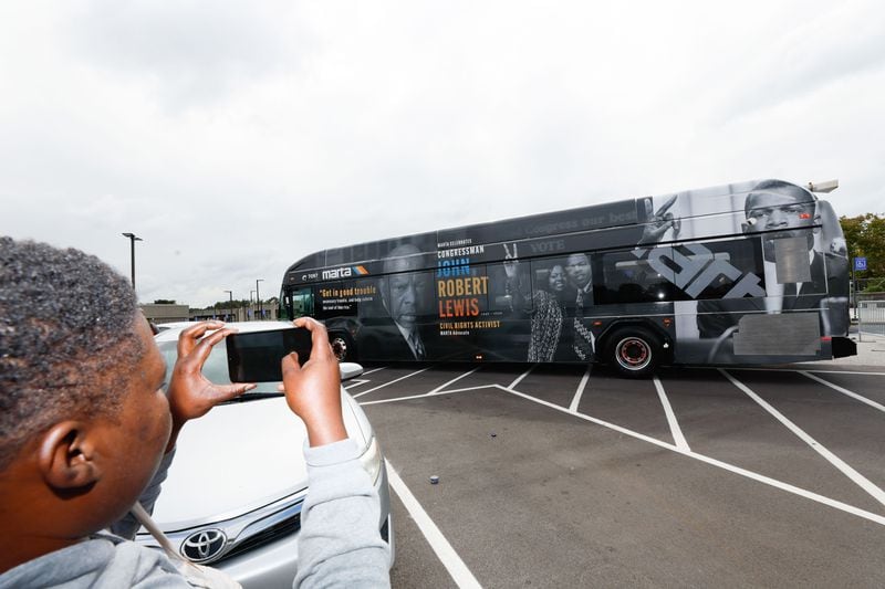 Lakesha Julien took a cellphone photo of the bus wrapped in honor of the late congressman and his wife, Lillian Miles Lewis, which was seen parked outside the College Park Station on Thursday, September 12, 2024. “I am happy to see his legacy continue to make history,” said Julien.
(Miguel Martinez / AJC)