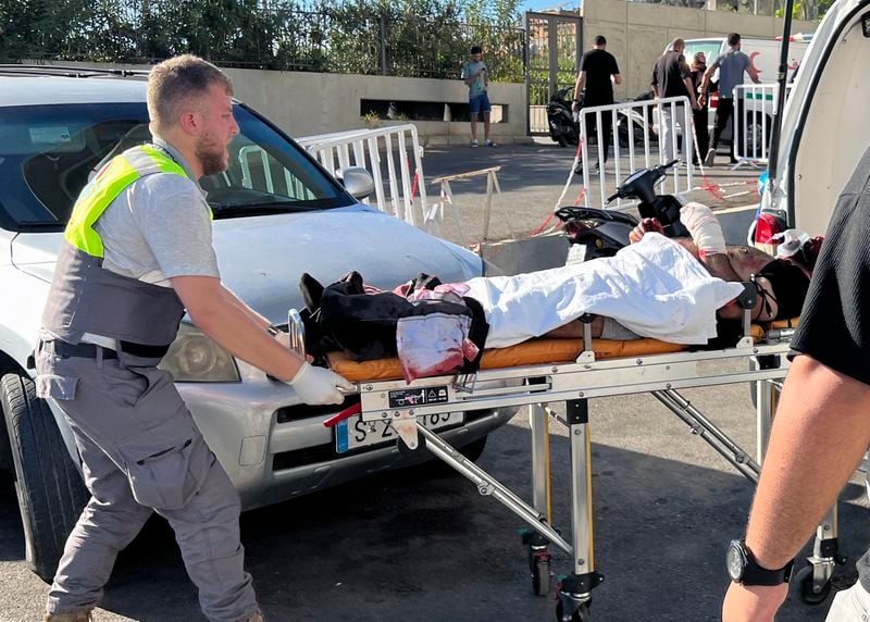 FILE - A Civil Defense first-responder carries a wounded man whose handheld pager exploded at al-Zahraa hospital in Beirut, on Sept. 17, 2024. (AP Photo/Hussein Malla, File)