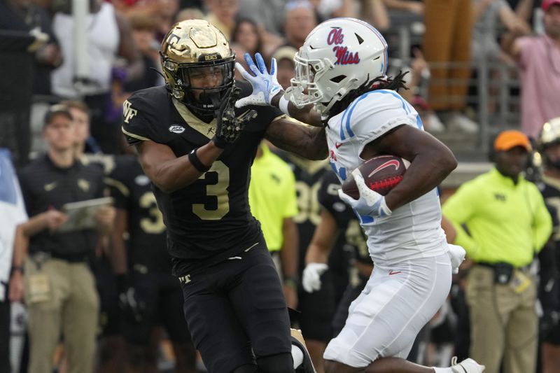 Mississippi running back Henry Parrish Jr. (21) pushes Wake Forest defensive back Capone Blue (3) away as he runs for a touchdown during the first half of an NCAA college football game in Winston-Salem, N.C., Saturday, Sept. 14, 2024. (AP Photo/Chuck Burton)