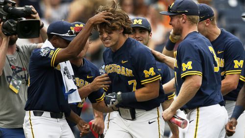 Michigan's Jesse Franklin (middle) is greeted by teammates after he hit a solo home run in the College World Series on June 17, 2019. (AP Photo/Nati Harnik)