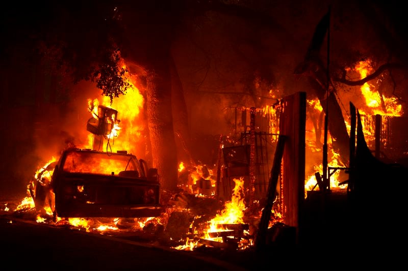 The Airport Fire burns a car and structure Tuesday, Sept. 10, 2024, in El Cariso, an unincorporated community in Riverside County, Calif. (AP Photo/Eric Thayer)