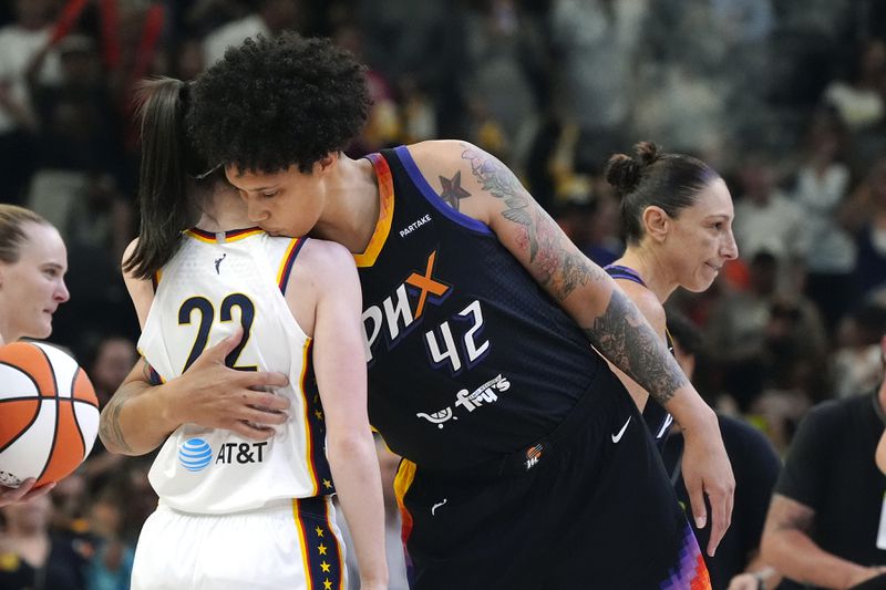Indiana Fever guard Caitlin Clark, left, gets a hug from Phoenix Mercury center Brittney Griner (42) prior to a WNBA basketball game, Sunday, June 30, 2024, in Phoenix. (AP Photo/Ross D. Franklin)