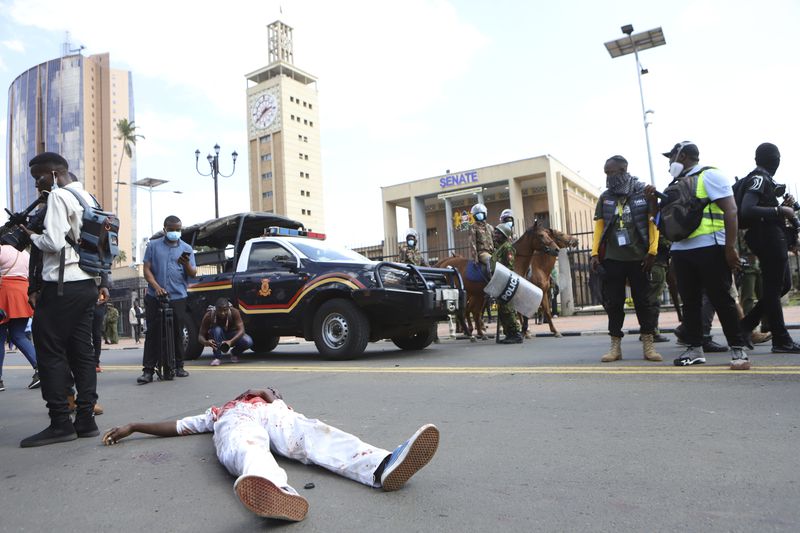 A body of a man who was shot in the head lies next to the Kenyan parliament during a protest over proposed tax hikes in a finance bill in downtown Nairobi, Kenya Tuesday, June. 25, 2024. (AP Photo/Brian Inganga)