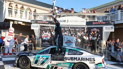 Alex Palou, right, kisses the trophy after winning his third IndyCar championship in four years Sunday, Sept. 15, 2024, at Nashville Superspeedway in Lebanon, Tenn. (AP Photo/Mark Humphrey)