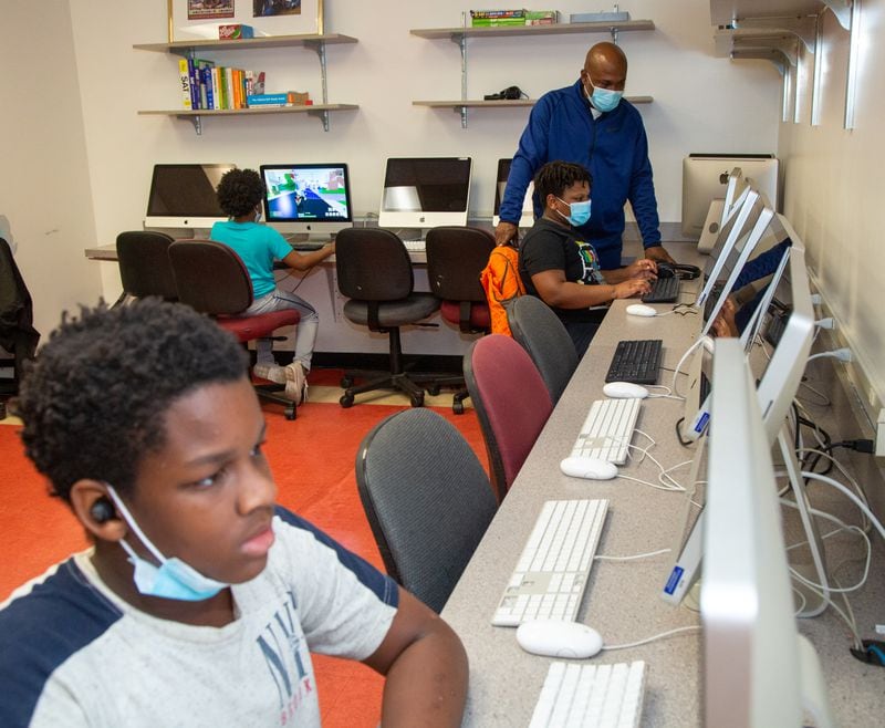 Program & facilities manager, George Epps (standing) helps Javontavious Coney (age 11) in the computer lab at The Rick McDevitt Youth Center.  PHIL SKINNER FOR THE ATLANTA JOURNAL-CONSTITUTION.