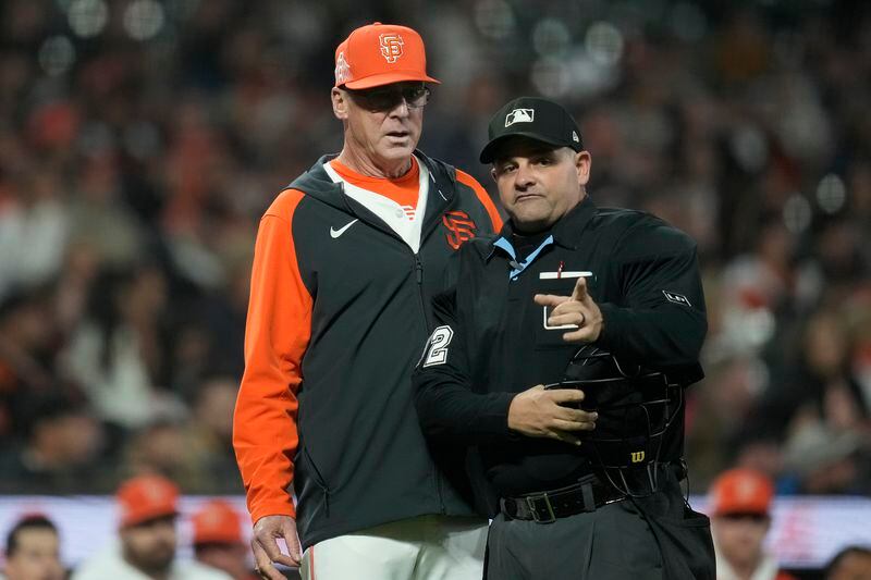 San Francisco Giants manager Bob Melvin, left, talks with umpire Jeremy Riggs after Tyler Fitzgerald was called out on batter interference during the 10th inning of a baseball game against the Atlanta Braves in San Francisco, Tuesday, Aug. 13, 2024. (AP Photo/Jeff Chiu)