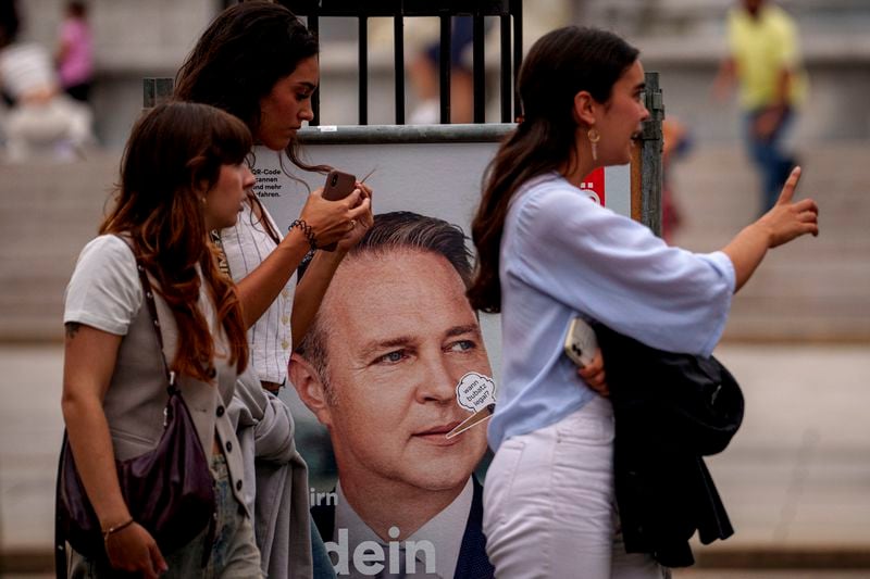 Women walk by posters of the Social Democratic, SPOe Party, showing Andreas Babler, in Vienna, Austria, Thursday, Sept. 26, 2024, ahead of the country's national election which will take place on Sept. 29. (AP Photo/Andreea Alexandru)