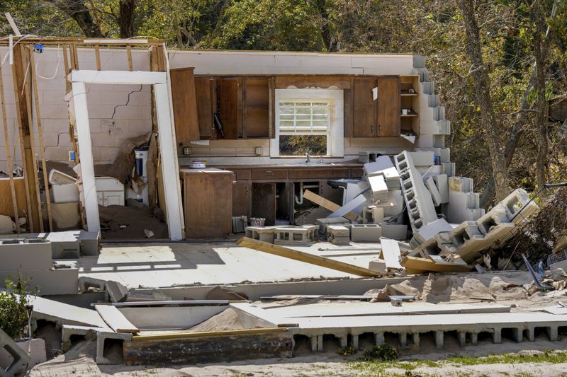 Damaged to one of the White family's homes that was destroyed by Hurricane Helene is seen, Tuesday, Oct. 1, 2024 in Morganton, N.C. The adjacent Catawba River flooded due to torrential rains destroying the seven of family's nine homes on the property. (AP Photo/Kathy Kmonicek)