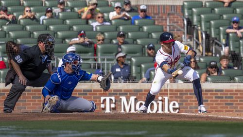 Atlanta Braves outfielder Eli White (36) hits a bunt in the 11th inning of a baseball game between the Toronto Blue Jays and the Atlanta Braves, Sunday, Sept. 9, 2024, in Atlanta. (AP Photo/Erik Rank)