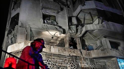 A firefighter stands in front of an apartment hit by an Israeli airstrike, in Beirut, Lebanon, Thursday, Oct. 3, 2024. (AP Photo/Hussein Malla)