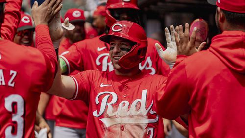 Cincinnati Reds outfielder Spencer Steer (7) celebrates in the dugout after scoring a run in the first inning of the first baseball game of a doubleheader against the Atlanta Braves, Wednesday, July 24, 2024, in Atlanta. (AP Photo/Jason Allen)