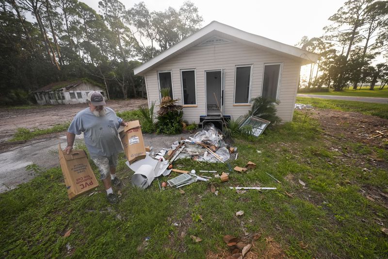 Will Marx cleans up remodeling debris in advance of Tropical Storm Helene, expected to become a hurricane before landfall, in Panacea, Fla., Wednesday, Sept. 25, 2024. (AP Photo/Gerald Herbert)