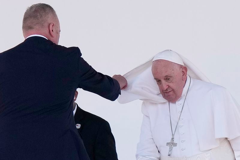 An aide assists Pope Francis with his cape after he gave an address during meeting with young people in the Sir John Guise Stadium in Port Moresby, Papua New Guinea, Monday, Sept. 9, 2024. (AP Photo/Mark Baker)