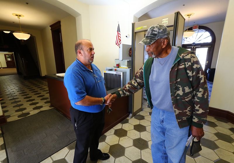 Former Putnam County High School principal Jacob Bennekin, right, thanks Deputy Sgt. John Harper for his 31 years of police service at the Putnam County Courthouse in Eatonton, where Harper leads courthouse security. (Curtis Compton / Curtis.Compton@ajc.com)