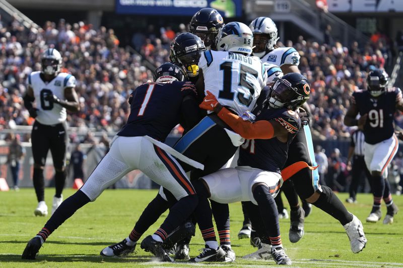 Carolina Panthers wide receiver Jonathan Mingo (15) is brought down by ;Chicago Bears cornerback Jaylon Johnson (1) and safety Kevin Byard III (31) during the second half of an NFL football game Sunday, Oct. 6, 2024, in Chicago. (AP Photo/Nam Y. Huh)