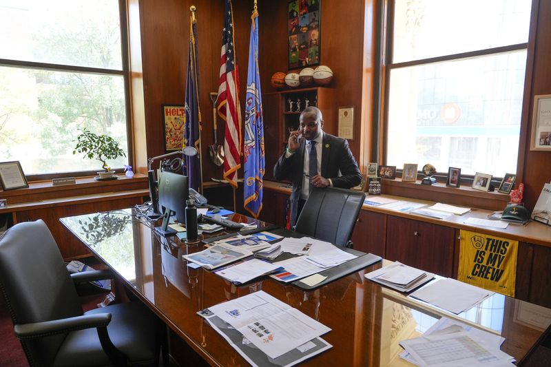 Milwaukee Mayor Cavalier Johnson talks on his phone after an Associated Press interview about the Republican National Convention coming to Milwaukee in his office Monday, July 1, 2024, in Milwaukee. (AP Photo/Morry Gash)