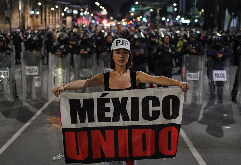 Student Daniela Camberos shows a banner in front of the police during a protest against government's proposed judicial reform, which would make judges stand for election, outside the Senate in Mexico City, Tuesday, Sept. 10, 2024. (AP Photo/Felix Marquez)