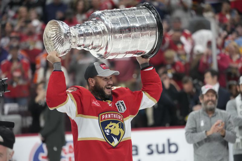 Florida Panthers right wing Kyle Okposo raises the NHL hockey Stanley Cup trophy after defeating the Edmonton Oilers, Monday, June 24, 2024, in Sunrise, Fla. (AP Photo/Wilfredo Lee)