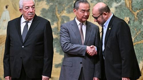 China's Foreign Minister Wang Yi, center, hosts an event for Mahmoud al-Aloul, left, vice chairman of Fatah, and Mussa Abu Marzuk, a senior member of Hamas, to meet at the Diaoyutai State Guesthouse in Beijing, Tuesday, July 23, 2024. (Pedro Pardo/Pool Photo via AP)