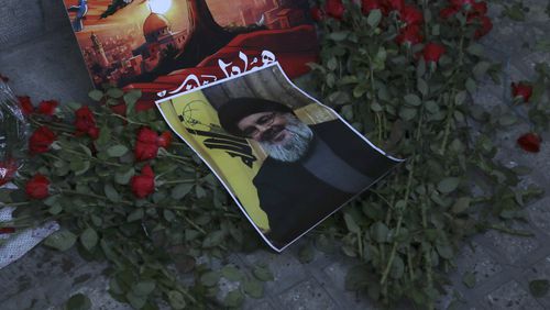 A poster of Hezbollah leader Sayyed Hassan Nasrallah is placed on flowers in front of the Lebanese Embassy in Tehran, Iran, Wednesday, Sept. 18, 2024. (AP Photo/Vahid Salemi)