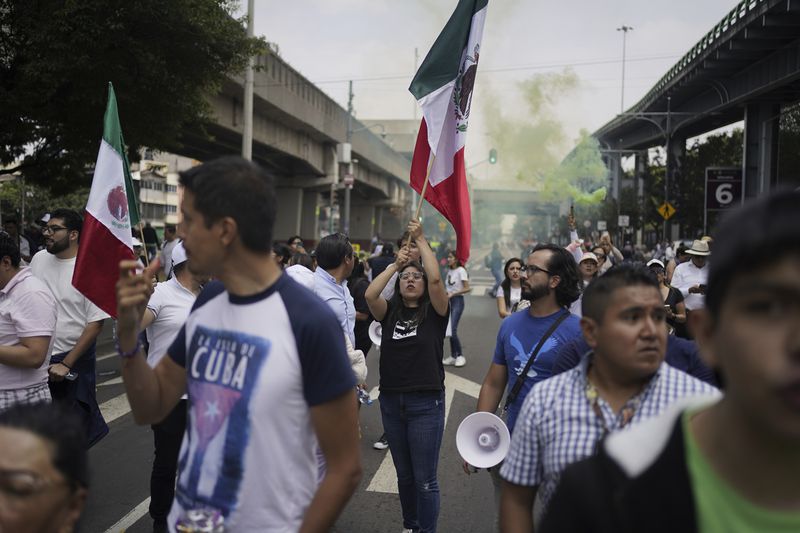 Law students block a street to protest against constitutional reform proposals that would make judges stand for election, outside a sports center where lawmakers are meeting as an alternative due to other demonstrators blocking Congress in Mexico City, Tuesday, Sept. 3, 2024. (AP Photo/Felix Marquez)