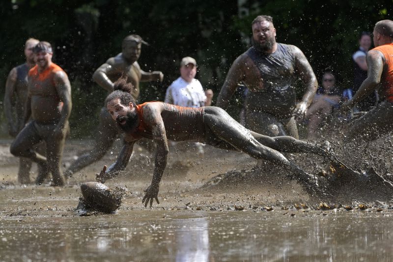 Andre Rioux, of Nashua, N.H., dives for the ball in a football game at the Mud Bowl in North Conway, N.H., Saturday, Sept. 7, 3024. (AP Photo/Robert F. Bukaty)