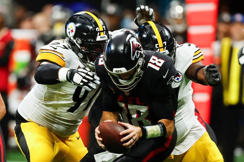 Atlanta Falcons quarterback Kirk Cousins (18) is sacked by Pittsburgh Steelers defensive tackle Cameron Heyward (97) and teammate defensive tackle Montravius Adams (57) during the second half of an NFL football game Sunday, Sept. 8, 2024, in Atlanta. (AP Photo/Butch Dill)