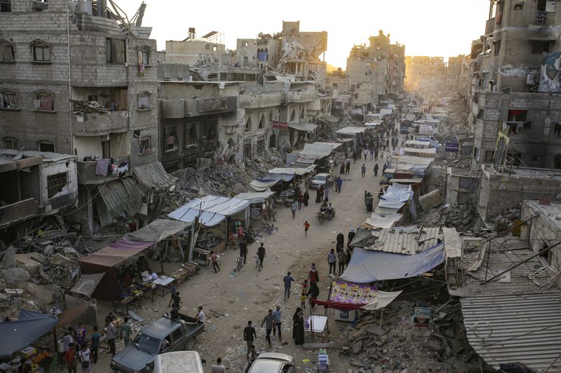 Palestinians displaced by the Israeli bombardment of the Gaza Strip walk through a street market in Khan Younis, southern Gaza Strip Saturday, June 29, 2024. (AP Photo/Jehad Alshrafi)