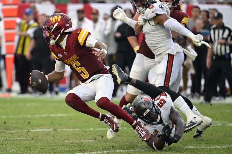 Washington Commanders quarterback Jayden Daniels (5) slips from a tackle by Tampa Bay Buccaneers linebacker Lavonte David during the second half of an NFL football game Sunday, Sept. 8, 2024, in Tampa, Fla. (AP Photo/Jason Behnken)