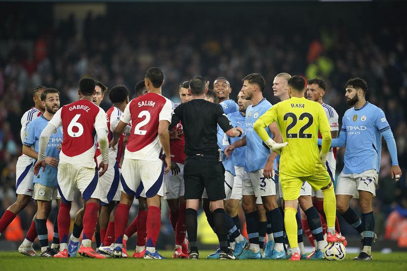 Players clash toward the end of the English Premier League soccer match between Manchester City and Arsenal at the Etihad stadium in Manchester, England, Sunday, Sept. 22, 2024. (AP Photo/Dave Thompson)