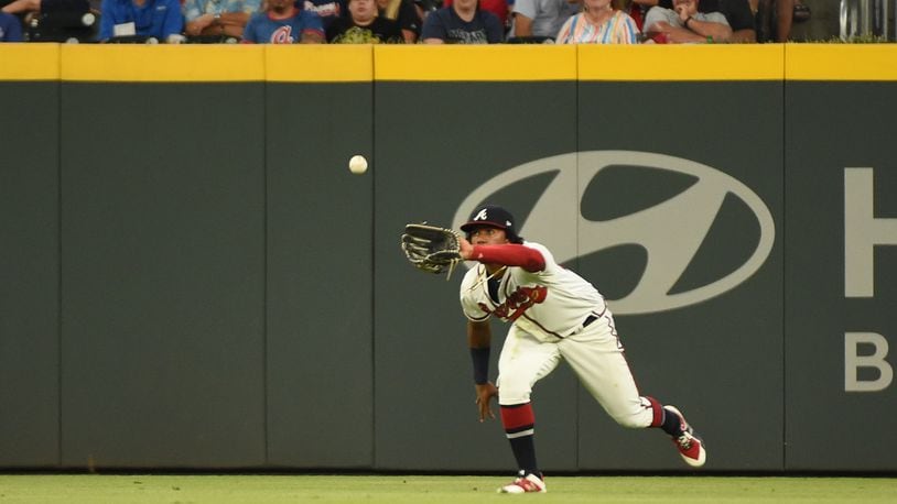 Atlanta Braves' Ronald Acuña Jr. knocked to the ground after two fans run  onto Coors Field
