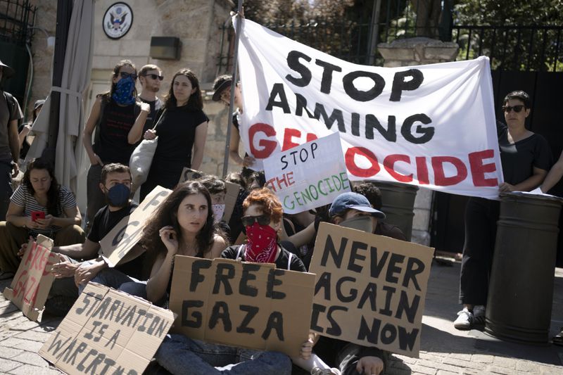Israeli and American activists block the entrance to the U.S. Consulate building that houses the Palestinian Affairs Unit, calling for the United States to stop providing arms to Israel for the war in the Gaza Strip, in Jerusalem, Friday, May 24, 2024. (AP Photo/Maya Alleruzzo)