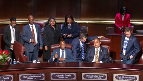 Council members look on as opponents of the law enforcement training center known to some as "Cop City" disrupt their meeting. After the protest on Sept. 16, 2024, the council approved an ordinance asking Invest Atlanta to issue $75 million in revenue bonds to finance 500 units of quick-delivery housing. (Arvin Temkar/Atlanta Journal-Constitution via AP)