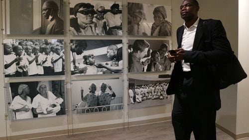 Dikembe Mutombo walks past photos from the Biamba Maria Mutombo Hospital in Kinshasa while leaving his office at the end of the work day on June 7, 2017, at the Dikembe Mutombo Foundation in Atlanta. (Curtis Compton/The Atlanta Journal-Constitution)